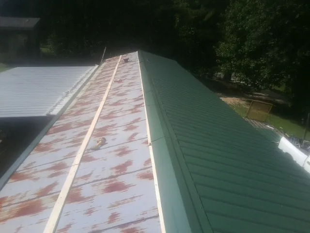 Old rusted panels beside newly installed green metal roofing — Wind Damage Roof Repair by Roofing Brothers in Bartlett