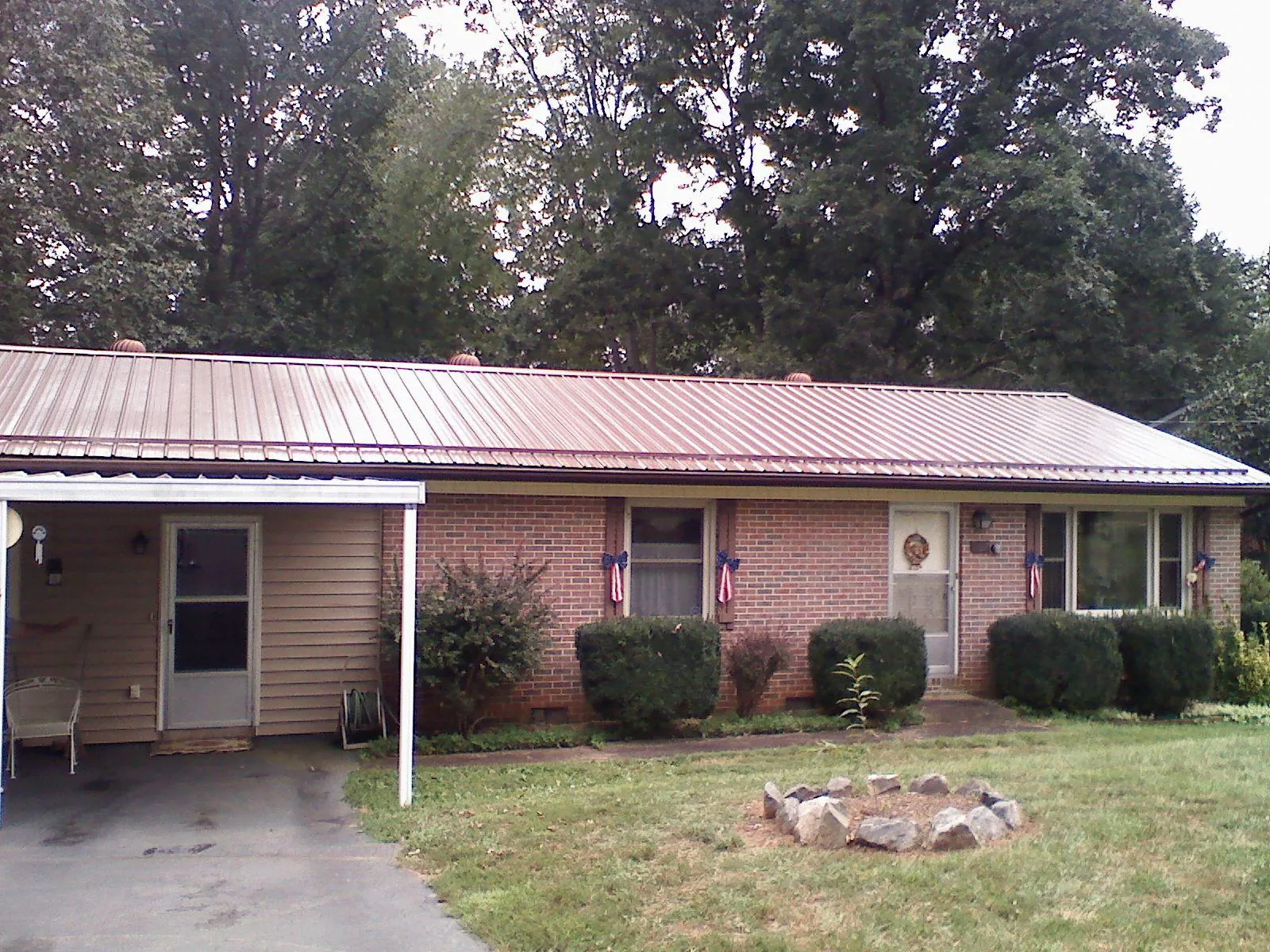Bronze metal roof and carport on a brick ranch home — Roof Repair work by our crew in Bartlett